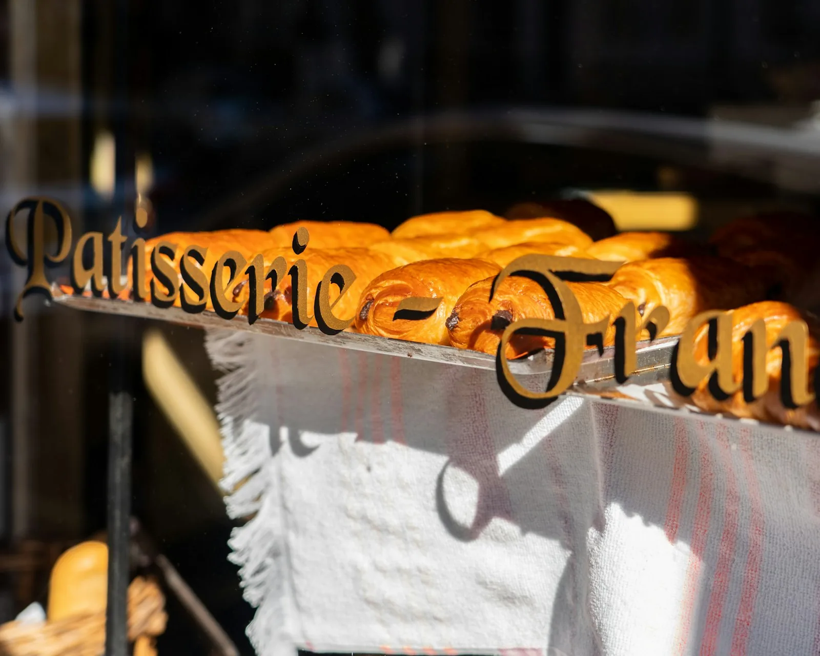 Vitrine et étal d'une boulangerie française avec pain et viennoiseries, éclairage chaleureux — décor typique d'un jeu concours en commerce de proximité